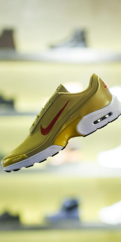 Stylish yellow sneaker showcased with blurred store background for a trendy vibe.