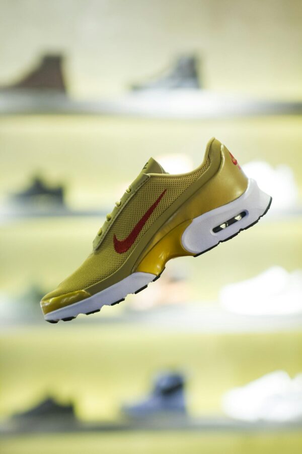 Stylish yellow sneaker showcased with blurred store background for a trendy vibe.
